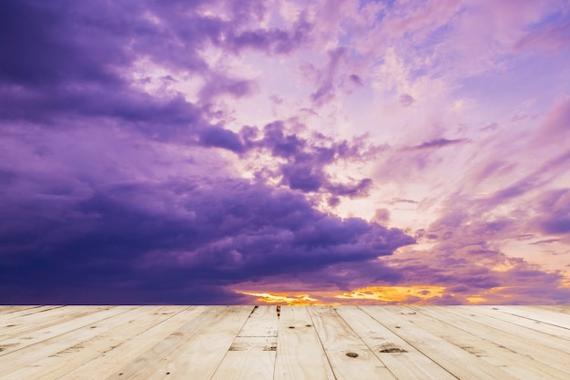 wood table and dramatic clouds sunset in thailand.