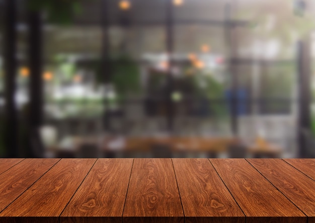 製品ディスプレイのモックアップのためのモダンなレストランの部屋やコーヒーショップのぼやけた背景の木製テーブル。