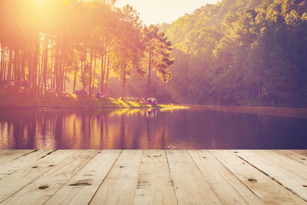 Photo wood table and pond water and sunrise with vintage effect.