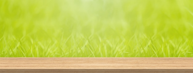Фото Деревянная столешница и размытие зеленой травы для размера и размера рекламного баннера