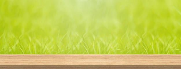 Wood table top and blur green grass for product and display montage banner size