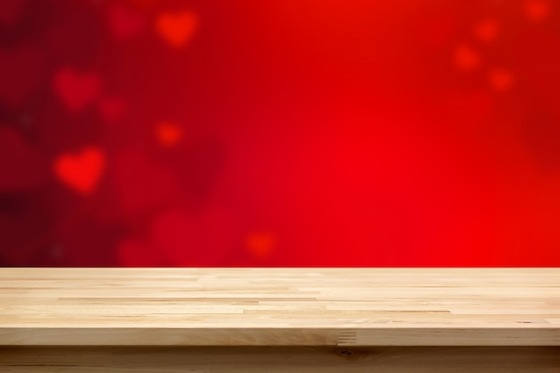 Wood table top on blur red heart abstract background