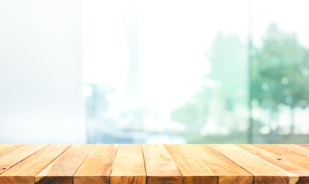 Wood table top on blur window glass,wall background with city view.For montage product display or design key visual layout