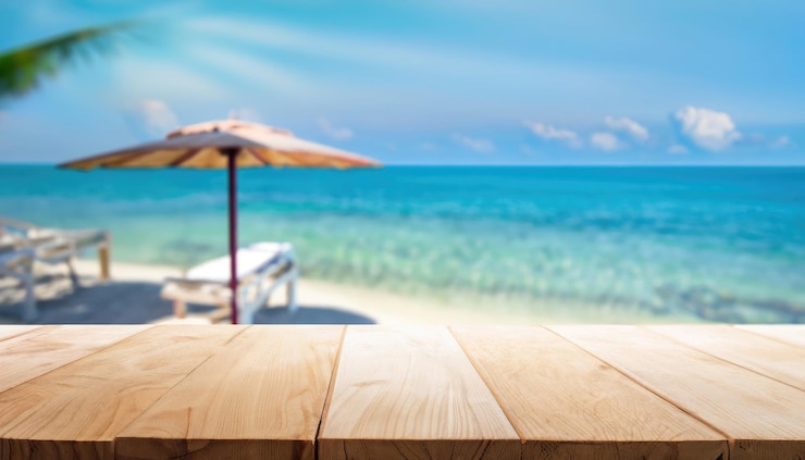 Photo wood table top on blurred blue sea and white sand beach background