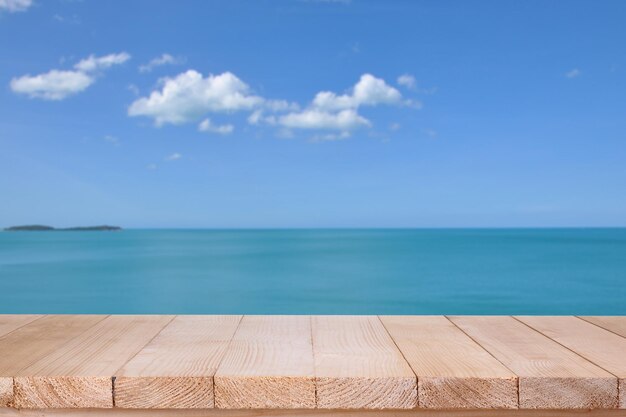 雲の背景にぼやけた青い海の上の木のテーブル