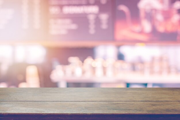 Wood table top and blurred cafe interior background with vintage filter