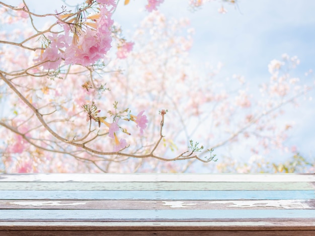 Photo wood table top and blurred flowers background with vintage filter