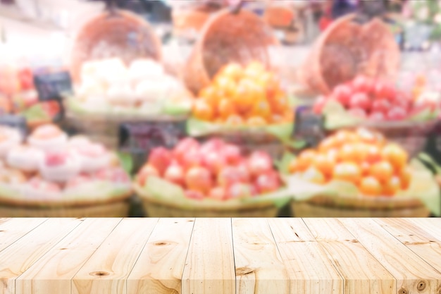 Wood table top on fruit store background.