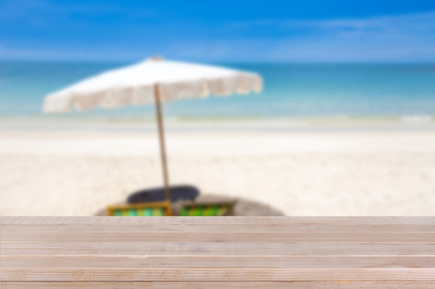 사진 흐린 푸른 바다와 하얀 모래 해변 배경에 나무 테이블 탑