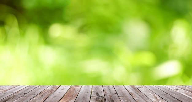 Wood table top on shiny bokeh green background. For product display, green nature bokeh background.