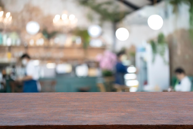 Wood table top with blur of people in coffee shop