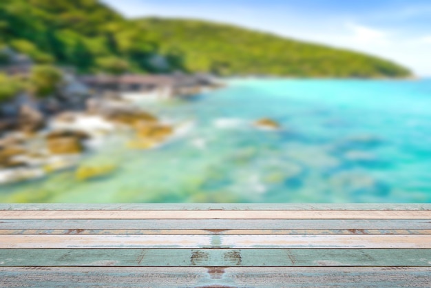 Wood table top with blurred nature scene tropical beach and blue sky holiday background concept  can be used for display or montage your products