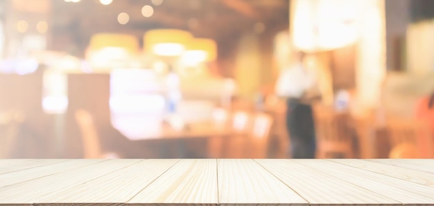 Деревянная столешница с ресторанным кафе или интерьером кофейни расфокусированным размытым фоном