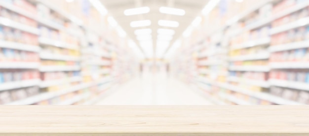 Wood table top with supermarket grocery store blurred\
background with bokeh light for product display