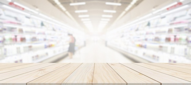 Wood table top with supermarket grocery store blurred
background with bokeh light product display