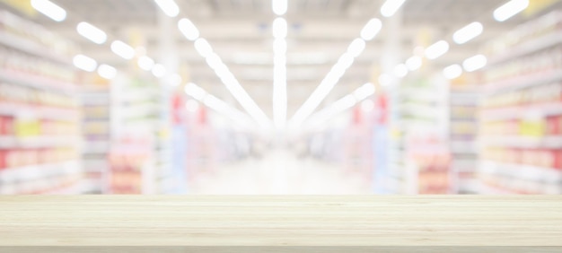 Wood table top with supermarket grocery store blurred background with bokeh light product display