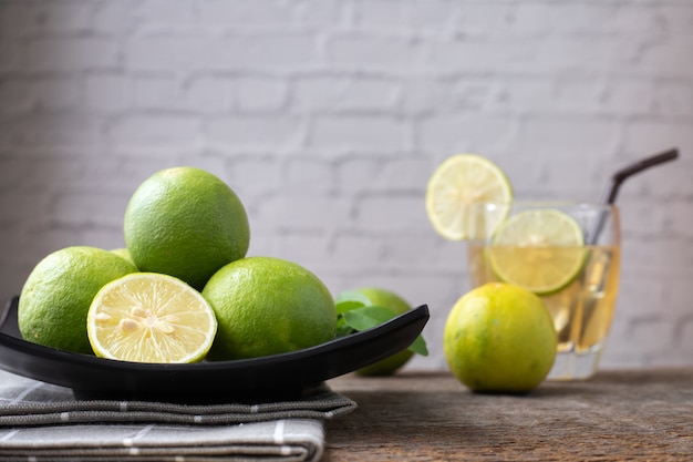 Tavolo in legno con succo di limone appena spremuto e fette di limone.