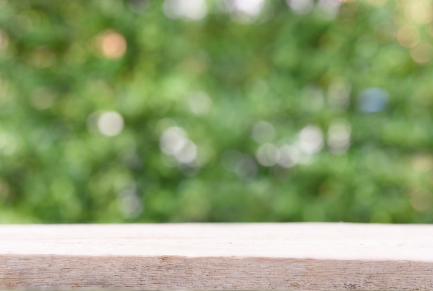 Wood table with space for products display and nature green blurred