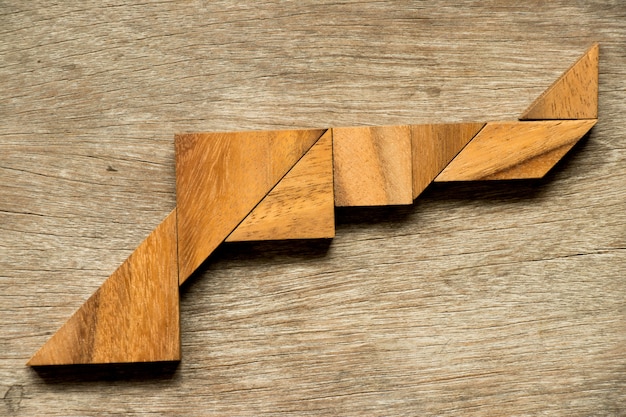 Foto puzzle di legno del tangram nella priorità bassa di figura della pistola