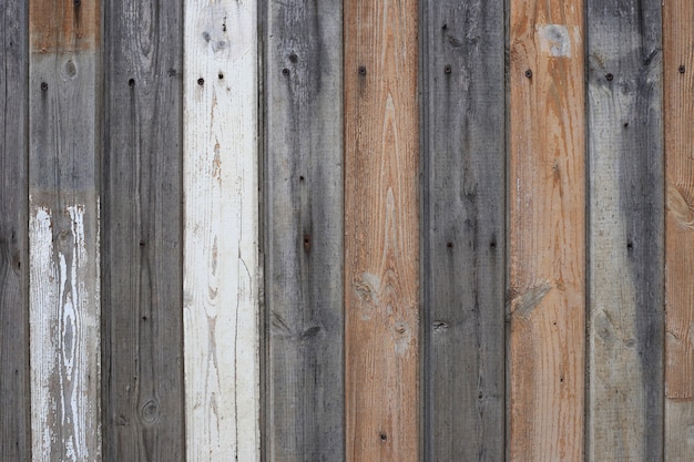 Wood texture background. Wooden fence made of brown gray and white painted boards