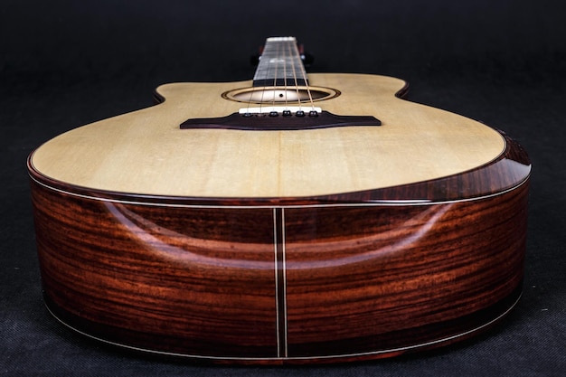 Wood texture of lower deck of six strings acoustic guitar on black background guitar shape