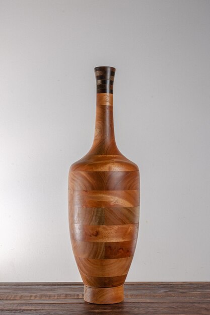 Wood vase over wood table on white wall background