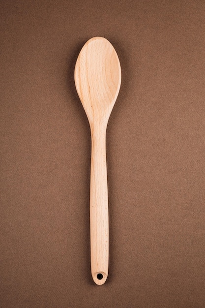 Wood or wooden spoon isolated on brown background