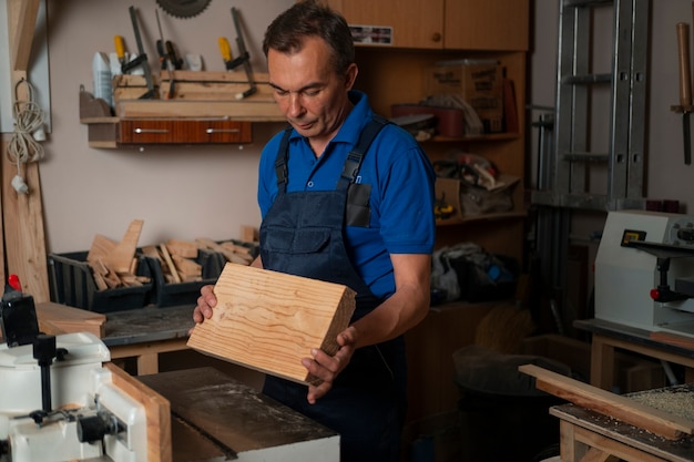 Фото Деревообработчик в своем магазине работает с инструментами и оборудованием