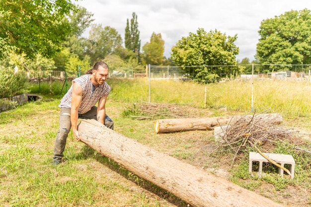 Woodcutter lifting a log with his bare hands