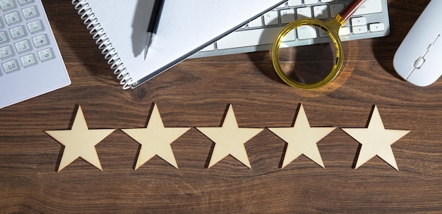 Wooden 5 stars with a business objects on the table Increase rating