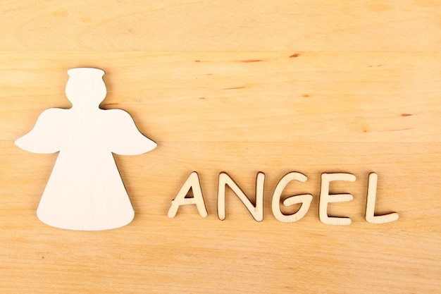 木製の天使と木製の背景に次の単語の天使