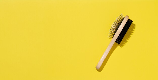 Photo wooden animal brush on yellow background top view