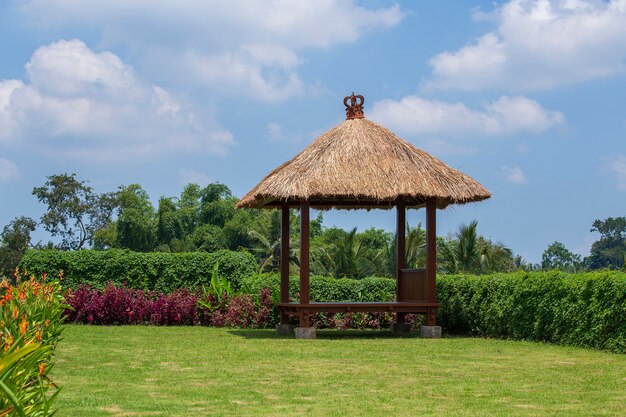 Wooden arbor with straw roof for relaxing in the tropical garden. Island Bali, Ubud, Indonesia