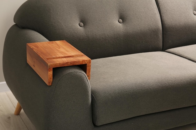 Wooden armrest table on sofa in room Interior element