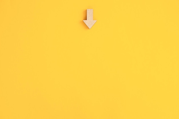 Wooden arrows point on yellow background Space for your text