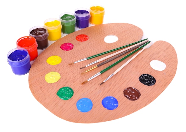 Wooden art palette with paint and brushes on white