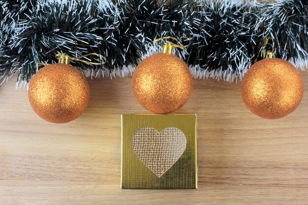 Photo wooden background, christmas decoration with balls and gifts, decorative tree branches