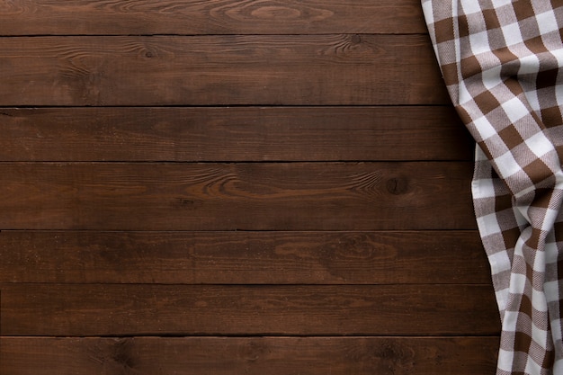 Wooden background with a checkered tablecloth. Copy space