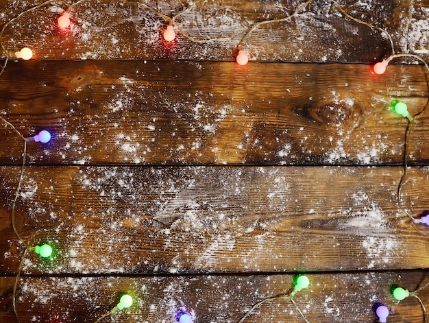 写真 クリスマスライト、ガーランド、散乱小麦粉のクローズアップと木製の背景。