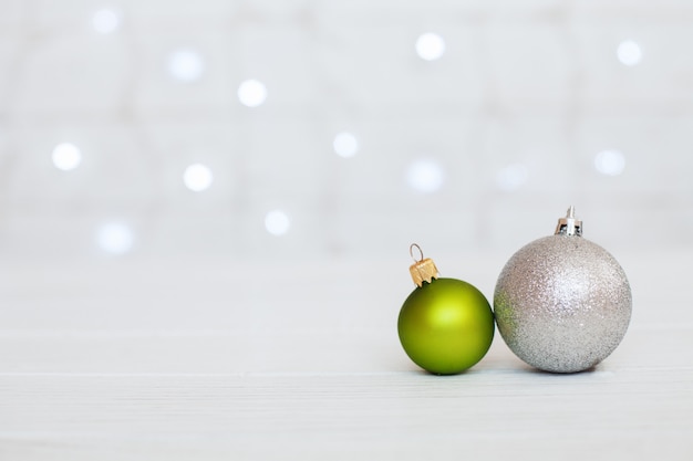 Wooden background with green balls and gifts.