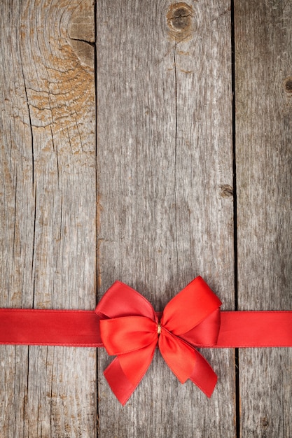 Wooden background with red bow and ribbon with copy space