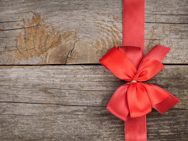 Wooden background with red bow and ribbon