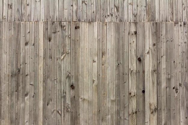 Wooden backgroundRustic wooden fence with slits and nailsNatural grey color