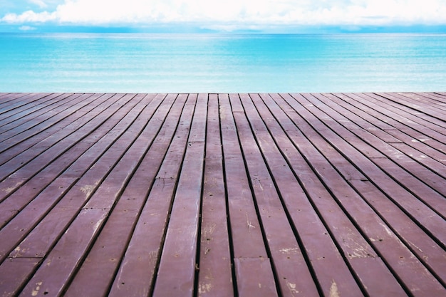 Wooden balcony that extends out to the sea at sky.