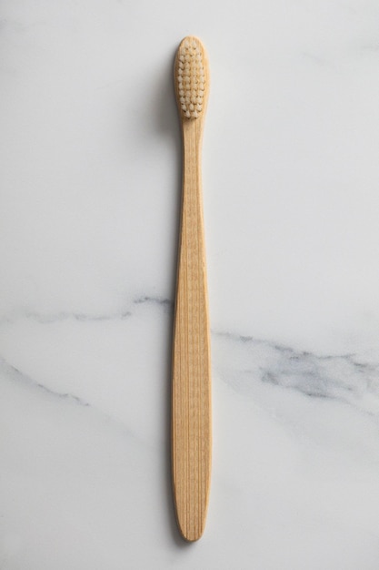 Wooden bamboo toothbrush on a marble background