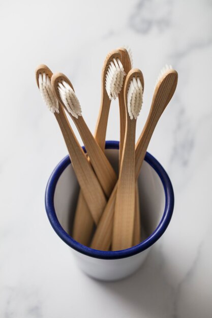 Wooden bamboo toothbrushs in a white pot