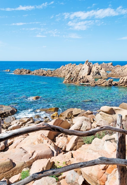 Wooden banister by Costa Paradiso rocky shore