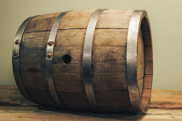 Wooden barrel on a old oak table Green background behind