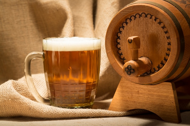 Wooden barrel with beer mug on canvas