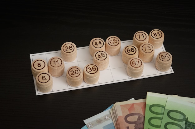 Lotto di botti di legno, carte ed euro. tavolo in legno nero.